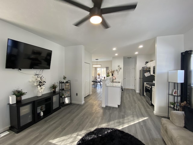 living room featuring ceiling fan, dark hardwood / wood-style floors, and sink