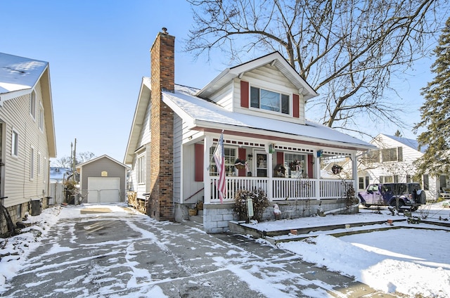 view of front of property featuring an outbuilding, a garage, and covered porch