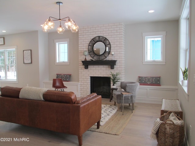 living room with a fireplace, a healthy amount of sunlight, and light wood-type flooring