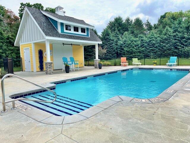 view of swimming pool with a patio and an outdoor structure