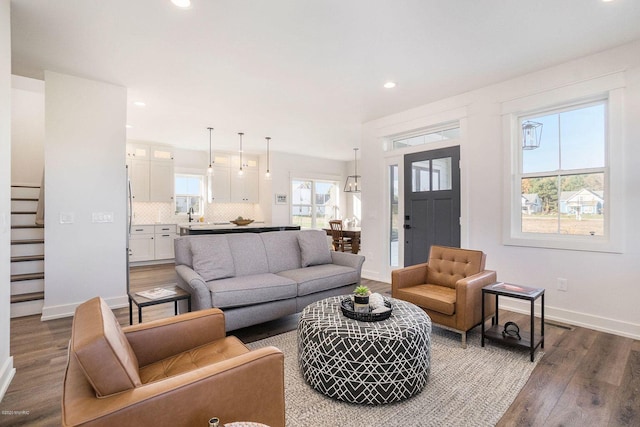 living room featuring sink and dark hardwood / wood-style flooring