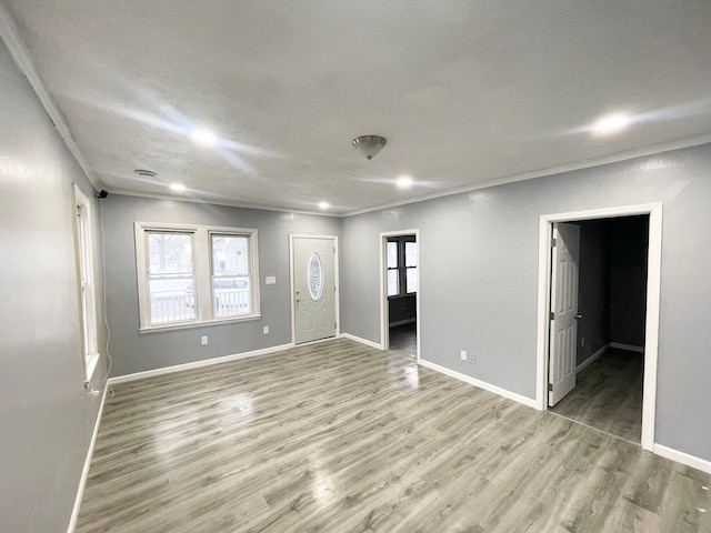 entryway featuring ornamental molding and light hardwood / wood-style flooring