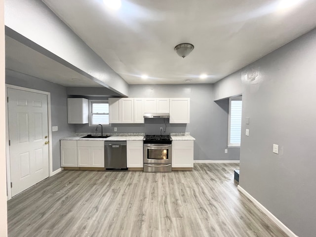 kitchen featuring stainless steel appliances, light hardwood / wood-style floors, sink, and white cabinets