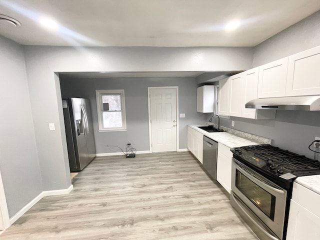 kitchen with white cabinetry, sink, stainless steel appliances, and light wood-type flooring