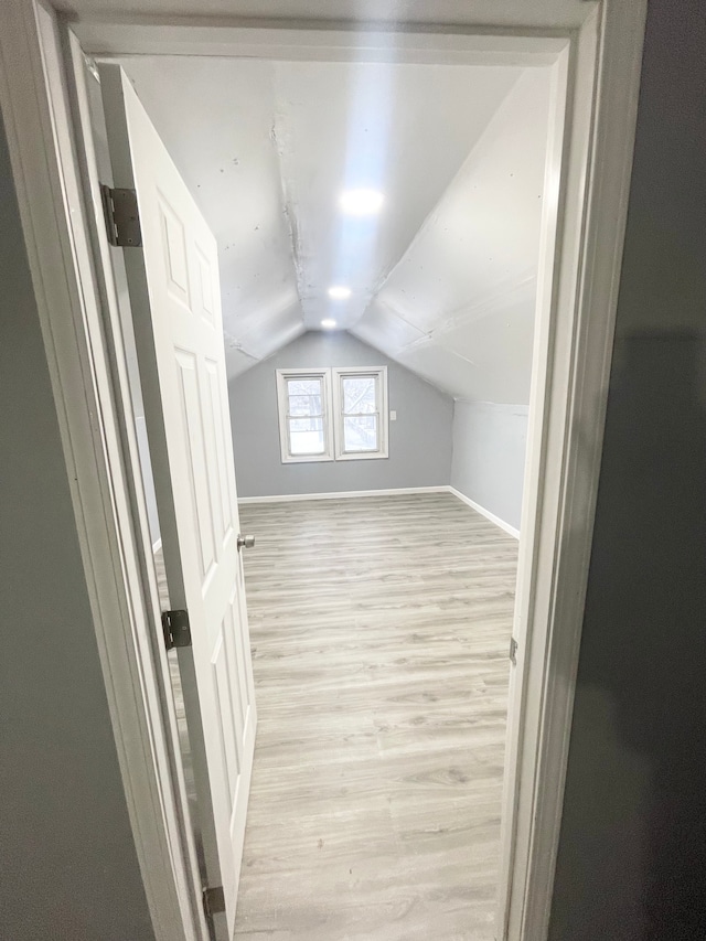 bonus room featuring lofted ceiling and light wood-type flooring