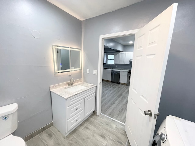 bathroom featuring vanity, hardwood / wood-style flooring, and toilet