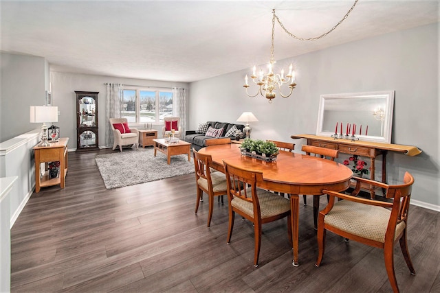 dining room with dark hardwood / wood-style floors and a notable chandelier