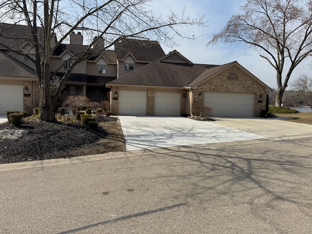 view of front of house featuring brick siding, roof with shingles, concrete driveway, and an attached garage