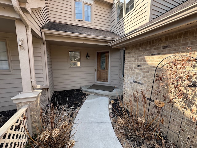 doorway to property featuring roof with shingles