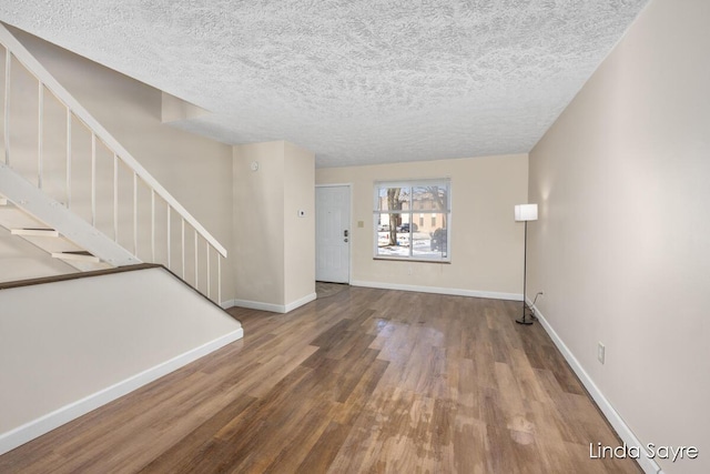 unfurnished living room with hardwood / wood-style floors and a textured ceiling