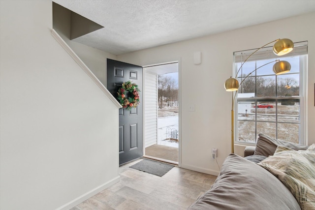 foyer featuring light wood-type flooring and a textured ceiling