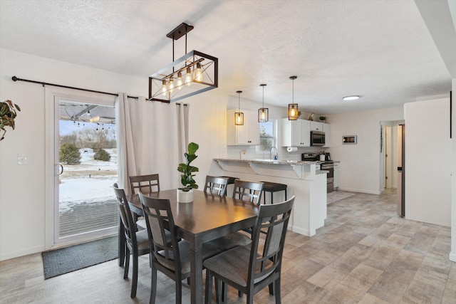 dining room featuring sink and a textured ceiling