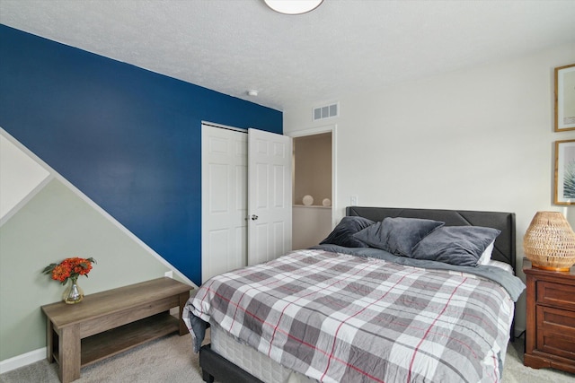 bedroom featuring a closet, a textured ceiling, and carpet flooring