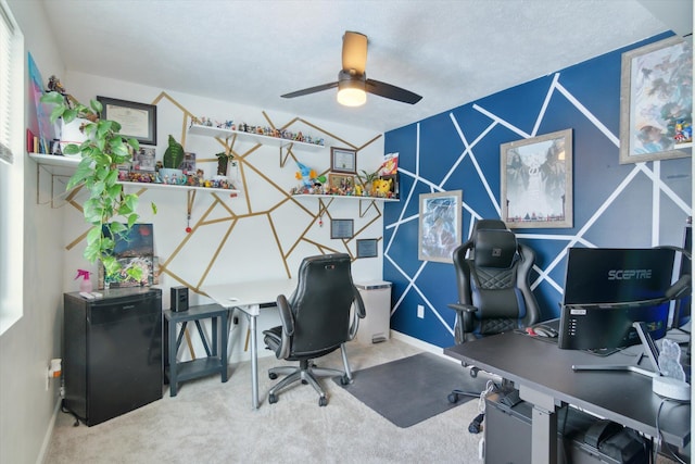 home office featuring carpet flooring, a textured ceiling, and ceiling fan