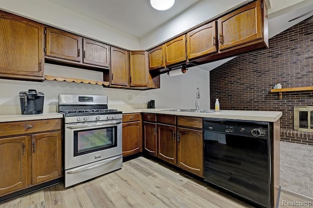 kitchen with sink, stainless steel gas stove, dishwasher, kitchen peninsula, and brick wall