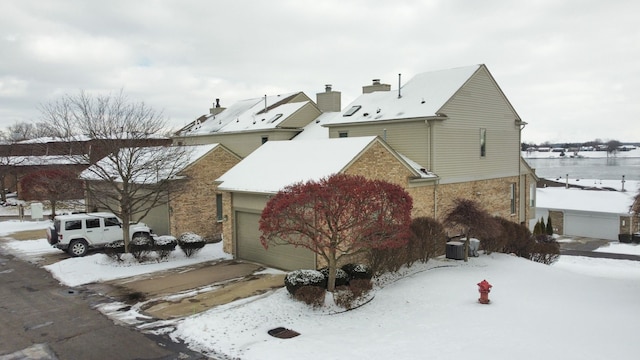 view of snow covered exterior with a garage