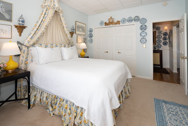 bedroom with carpet, a closet, and a drop ceiling