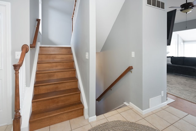 stairs featuring ceiling fan and tile patterned floors