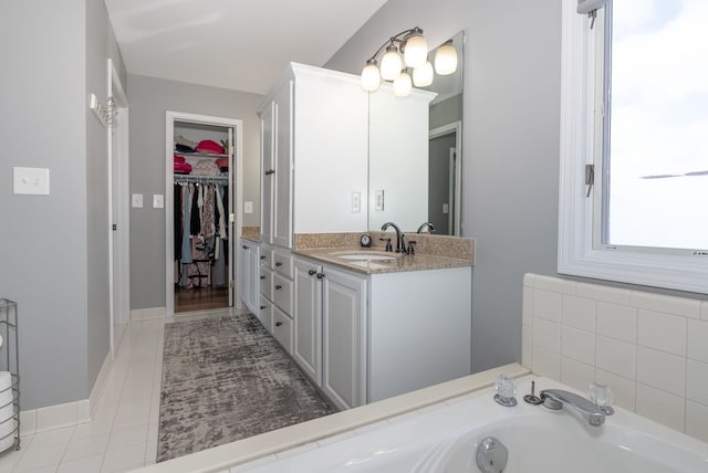 bathroom featuring vanity, tile patterned flooring, and a bathing tub