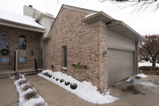 view of snow covered exterior with a garage