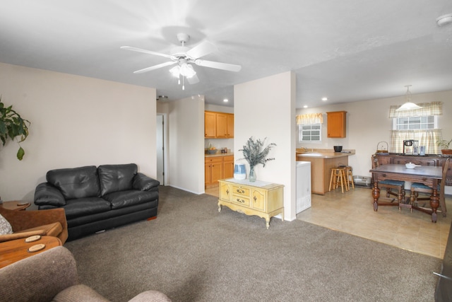 carpeted living room with ceiling fan