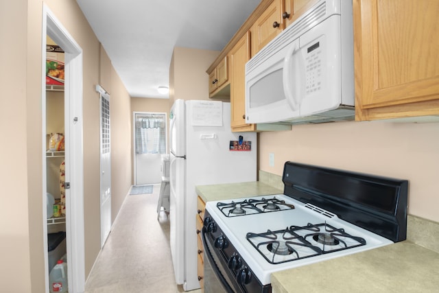 kitchen featuring white appliances and light brown cabinets