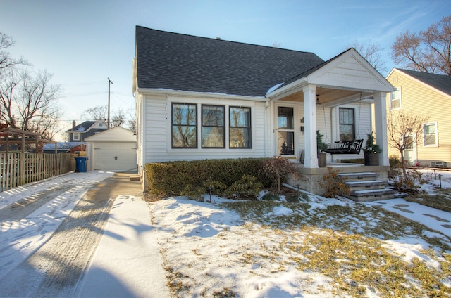 bungalow with an outbuilding, a garage, and a porch