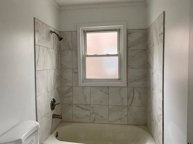 bathroom with tiled shower / bath combo and toilet