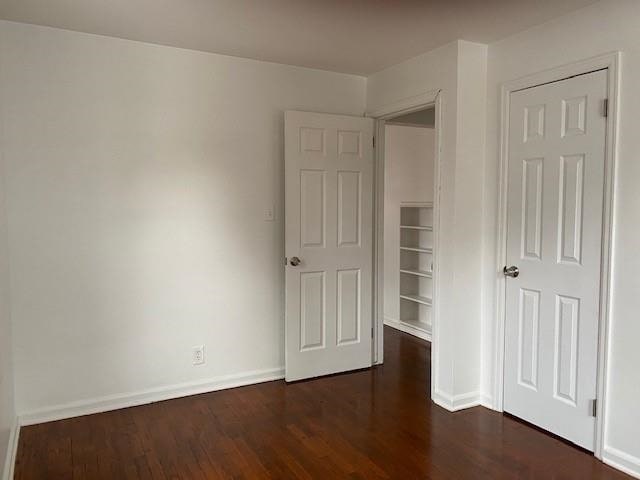 unfurnished bedroom featuring dark hardwood / wood-style flooring