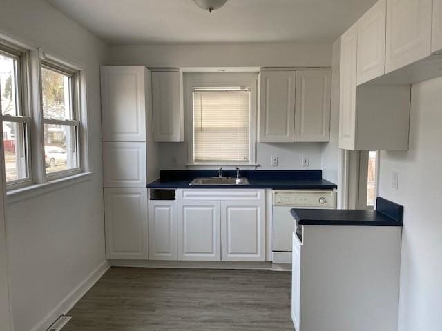 kitchen with dark wood-type flooring, white dishwasher, sink, and white cabinets