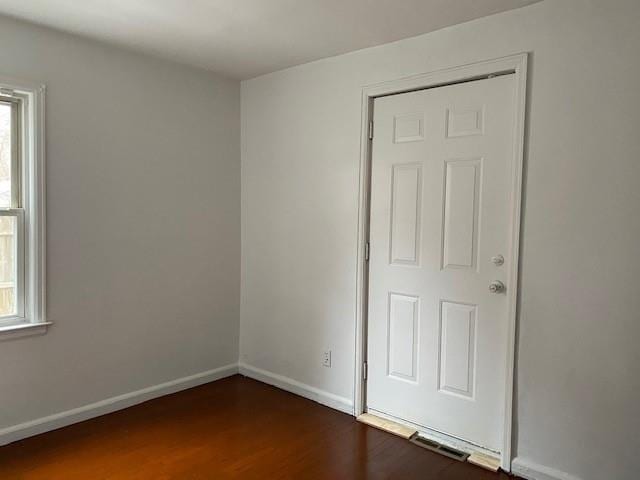 spare room with dark wood-type flooring