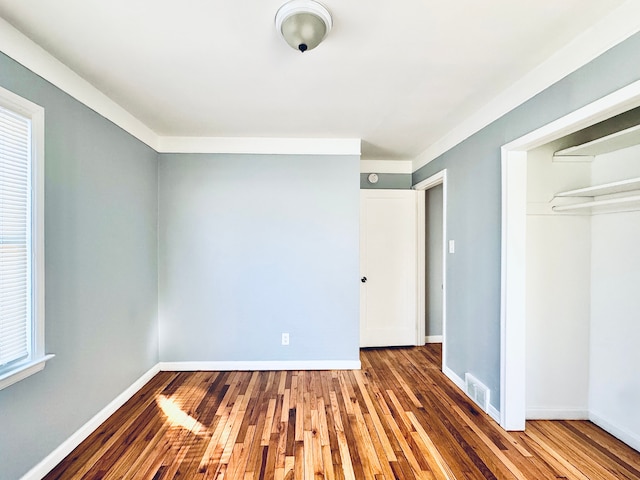 unfurnished bedroom featuring dark hardwood / wood-style flooring and a closet