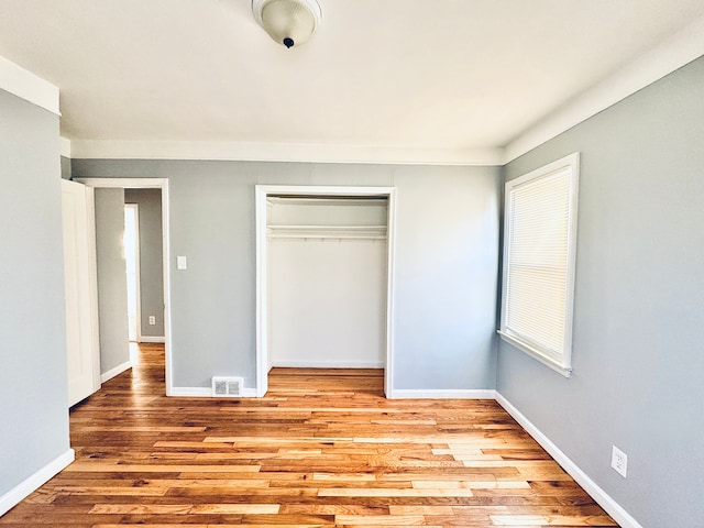 unfurnished bedroom featuring light hardwood / wood-style floors and a closet