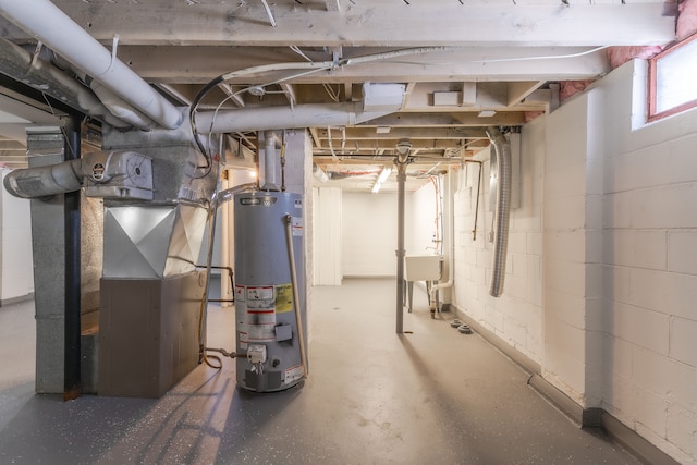 basement featuring water heater, sink, and heating unit