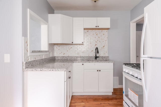 kitchen featuring white cabinetry, white appliances, sink, and light stone counters