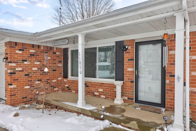 11870 Woodland Dr, Lennon, MI 48449 - snow covered property entrance with a porch and brick siding