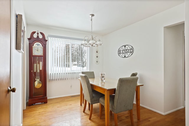 11870 Woodland Dr, Lennon, MI 48449 - dining area with a chandelier, wood finished floors, and baseboards
