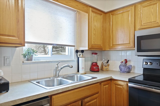 11870 Woodland Dr, Lennon, MI 48449 - kitchen with stainless steel appliances, a sink, light countertops, and tasteful backsplash