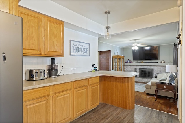 11870 Woodland Dr, Lennon, MI 48449 - kitchen featuring freestanding refrigerator, a peninsula, dark wood-style floors, open floor plan, and backsplash