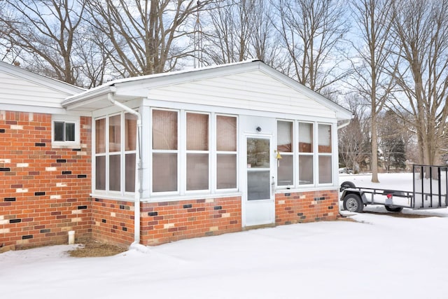 11870 Woodland Dr, Lennon, MI 48449 - view of snow covered exterior featuring a sunroom and brick siding