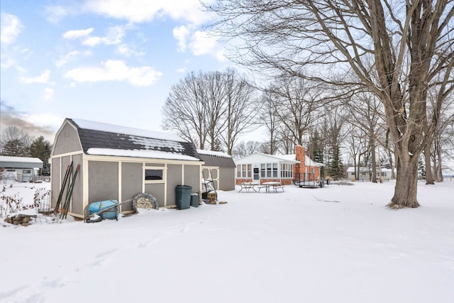 11870 Woodland Dr, Lennon, MI 48449 - snow covered rear of property featuring a gambrel roof, an outbuilding, and roof with shingles