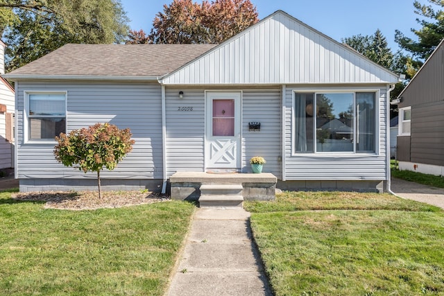 bungalow-style house with roof with shingles and a front yard