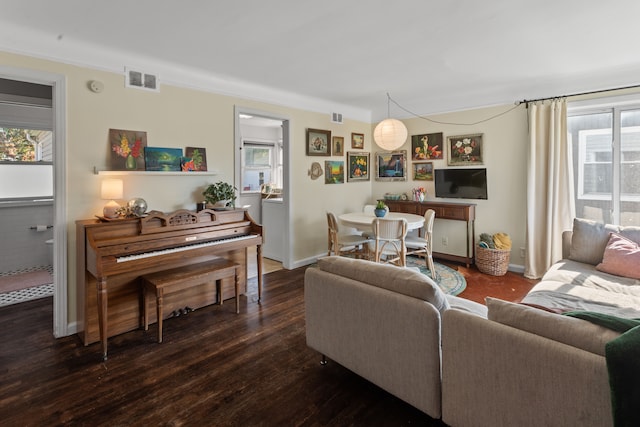 living room with dark wood-style flooring, visible vents, plenty of natural light, and baseboards