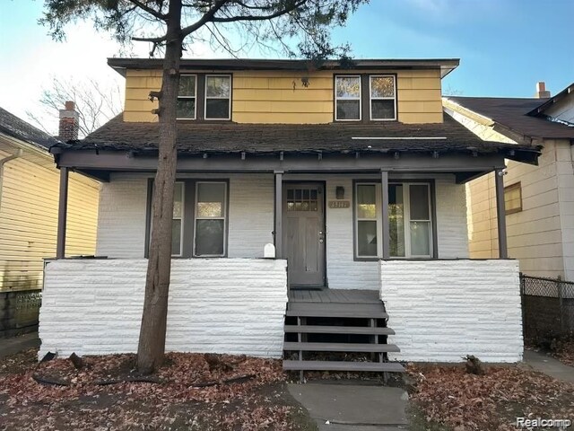 bungalow featuring a porch and roof with shingles