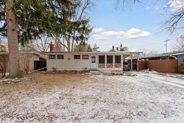 snow covered property with a carport