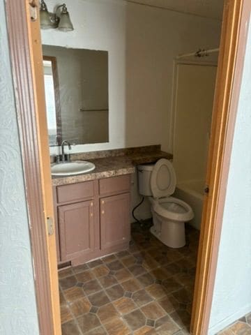 bathroom featuring vanity, toilet, and a shower