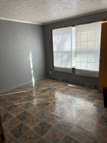 unfurnished room featuring a textured ceiling