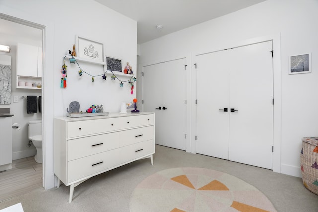 bedroom featuring two closets and ensuite bath