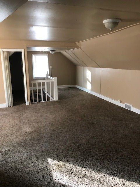 bonus room featuring lofted ceiling and carpet floors