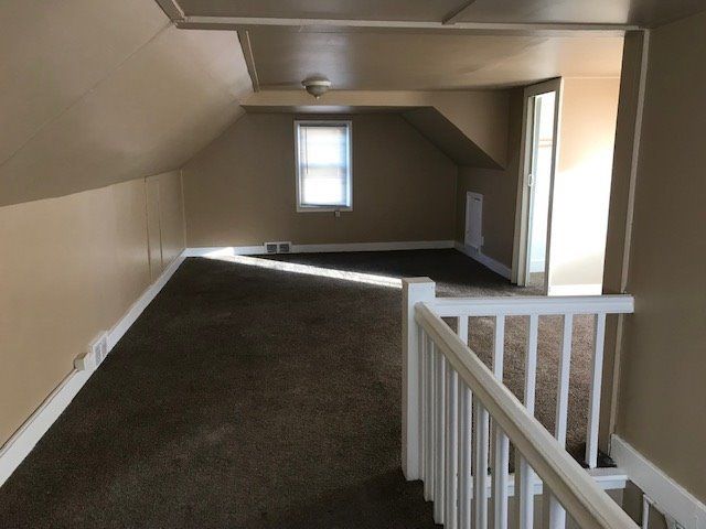 bonus room featuring carpet flooring and vaulted ceiling